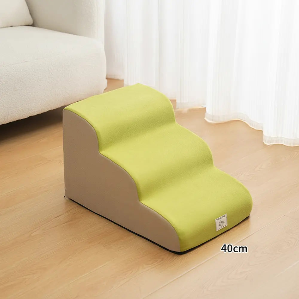 Perro pequeño usando una rampa de escalones suaves para llegar a un sofá con un apoyo más estable - vivaessencepet