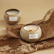 A hand-poured soy wax candle in a natural coconut shell, creating a serene, tropical home fragrance by vivaessencepet
