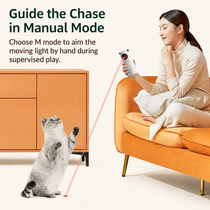 Person guiding an automatic laser cat toy in manual mode while a cat follows the light
